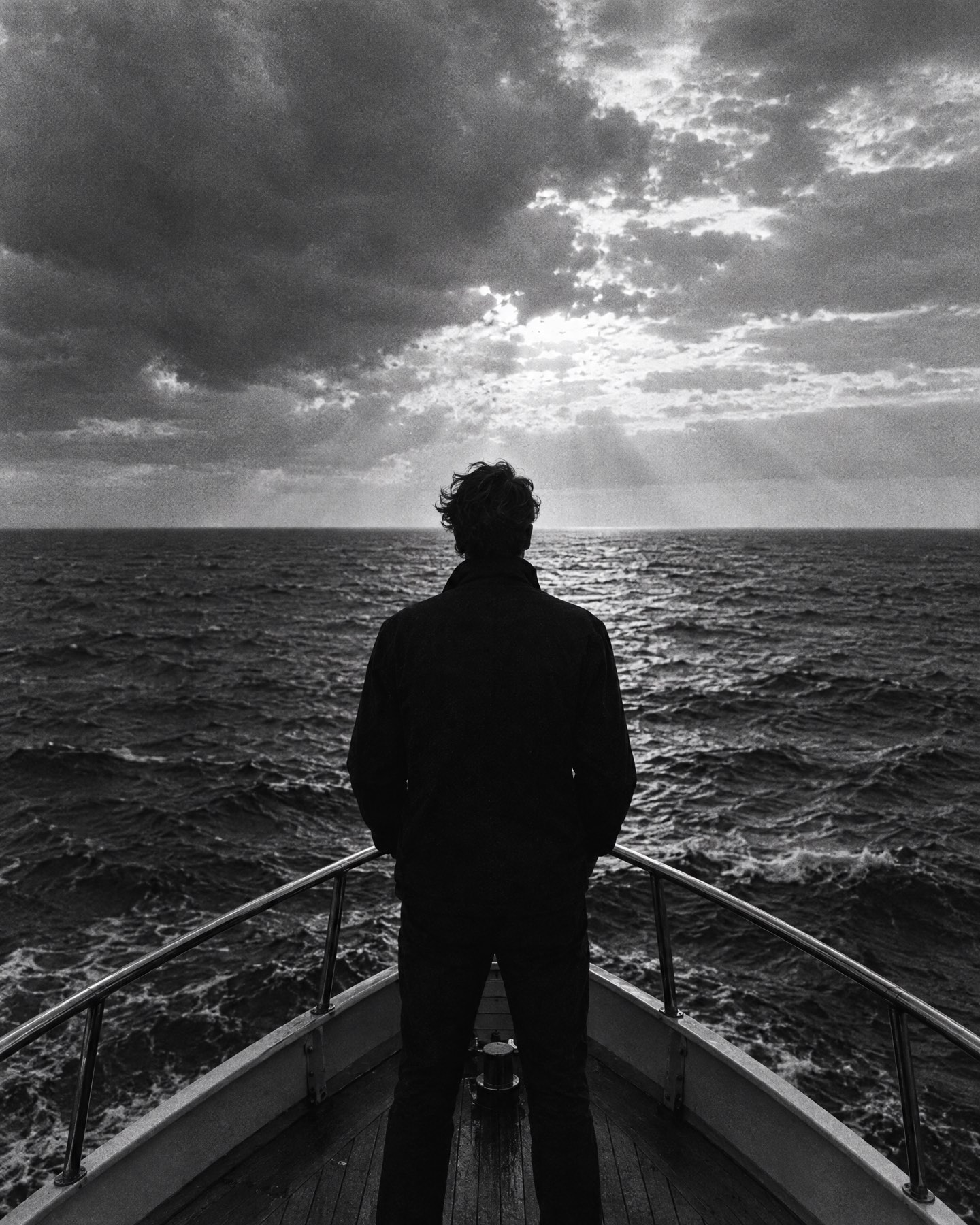 Hombre en la proa de un bote mirando el horizonte