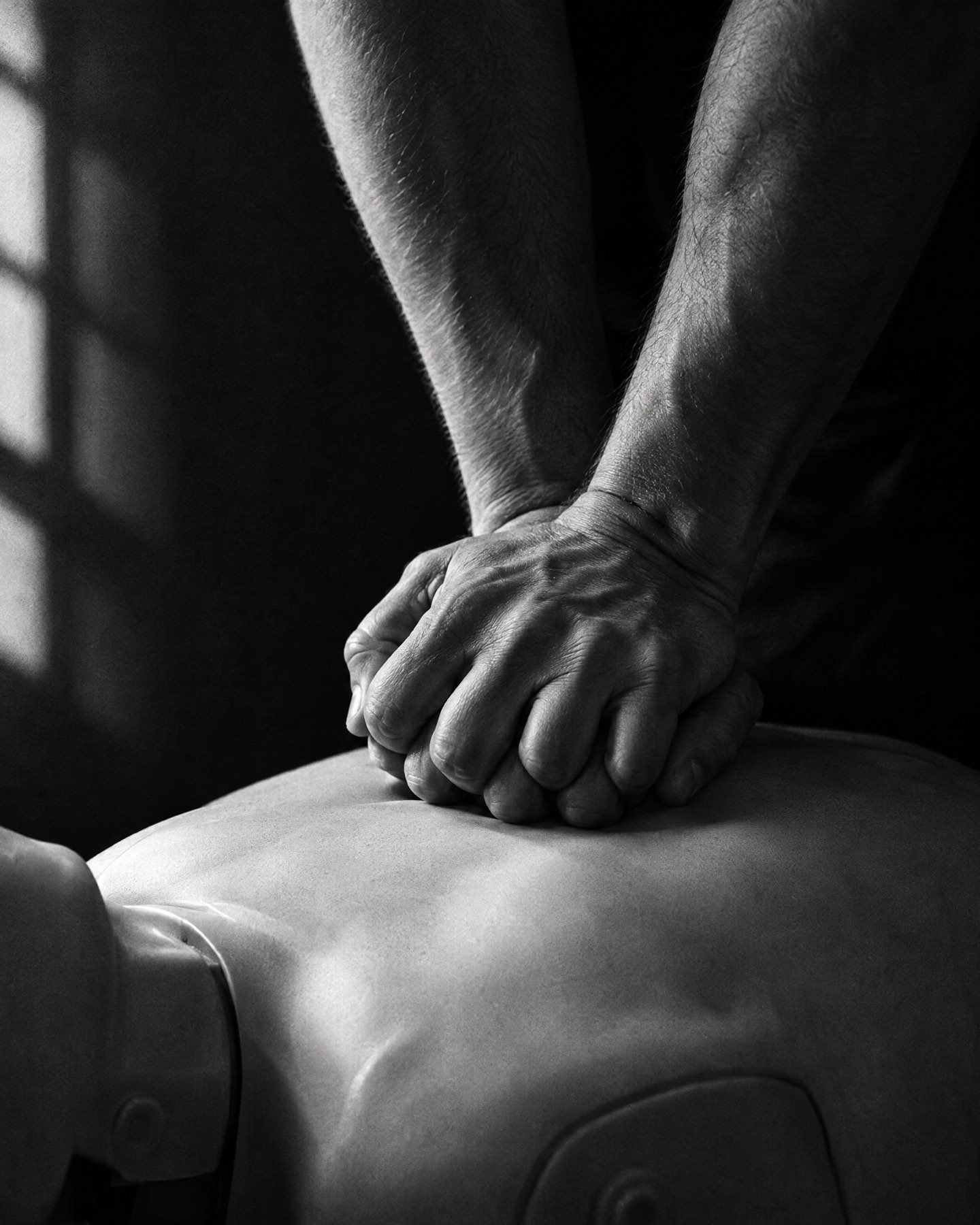 Manos realizando compresiones de CPR en un maniquí